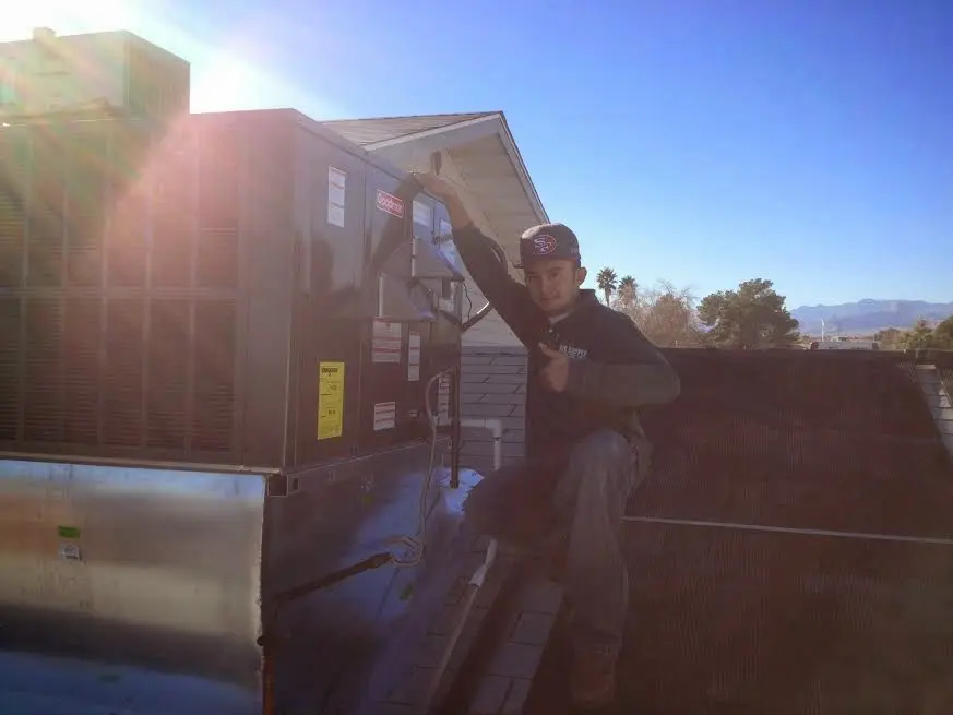 HVAC technician performing HVAC Inspection on a rooftop unit in Delmar